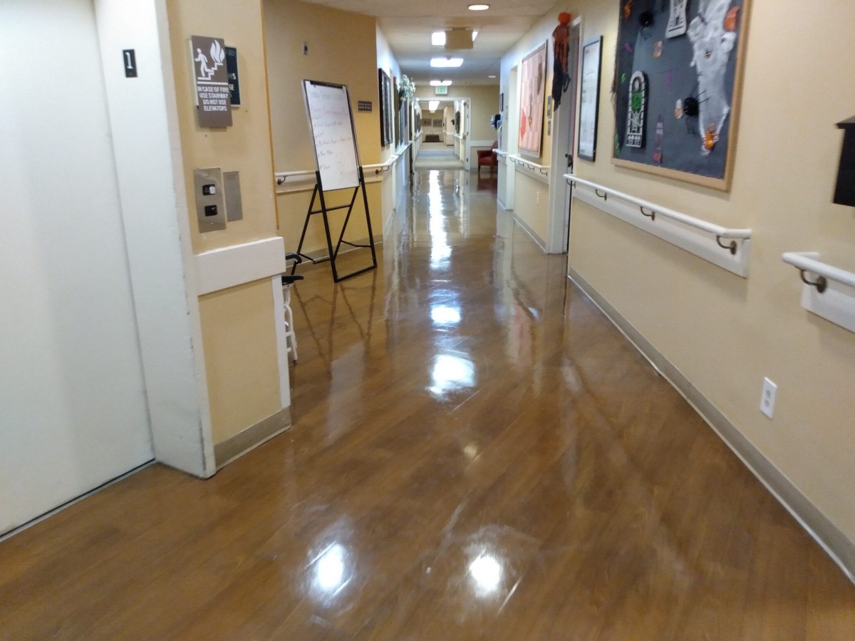 A clean and well-lit hospital hallway with shiny floors.