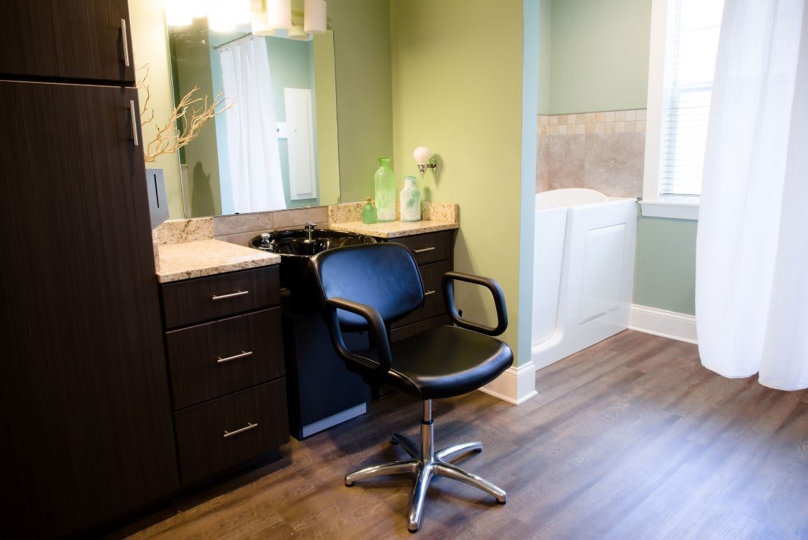 A modern salon setup with a styling chair and vanity mirror.