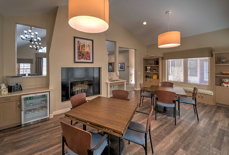 A modern dining area featuring wooden furniture, pendant lights, and a cozy fireplace.