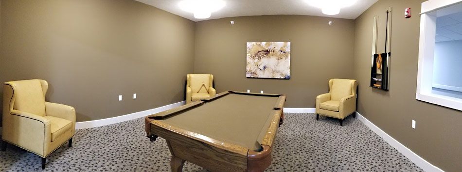 A cozy game room featuring a pool table and comfortable seating.