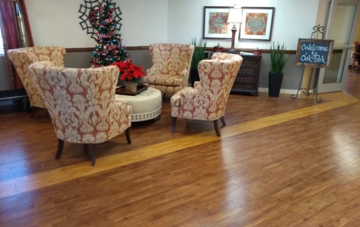A cozy living room setup with patterned chairs, a central table, potted plants, and decorative elements.