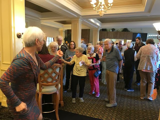 A lively social gathering with seniors engaged in conversation and activities.