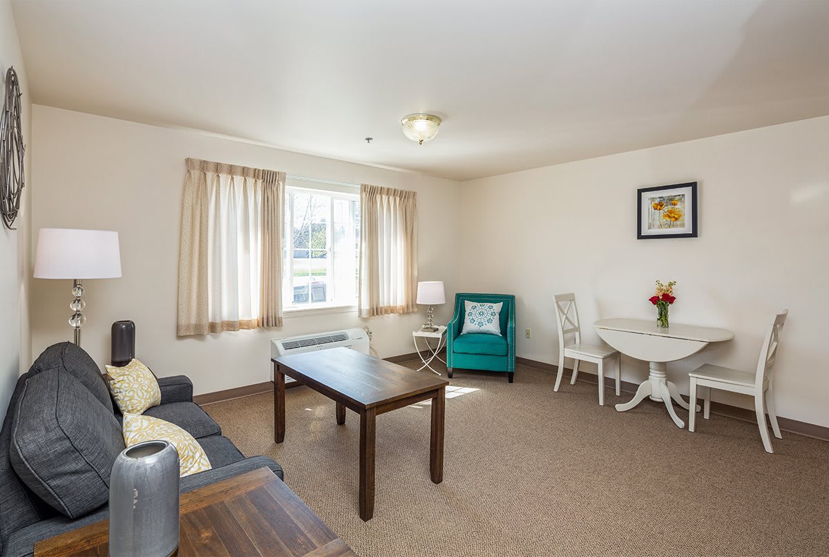 A cozy and bright living room with comfortable seating and a wooden table.