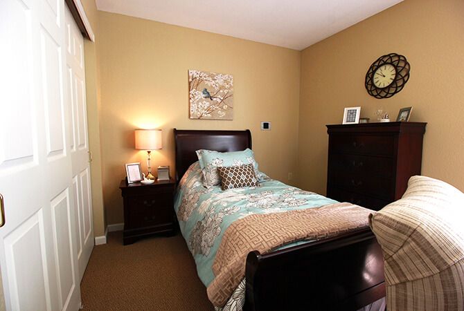 A cozy bedroom with a single bed, warm lighting, and decorative elements.