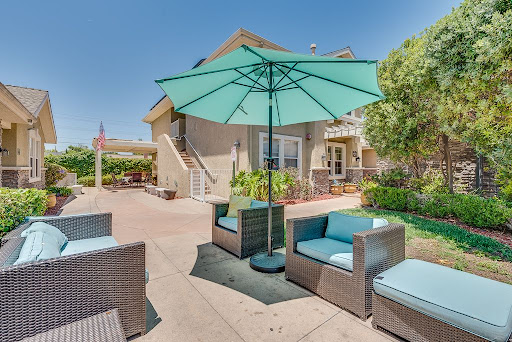 A cozy outdoor patio setup with comfortable seating and an umbrella for shade.