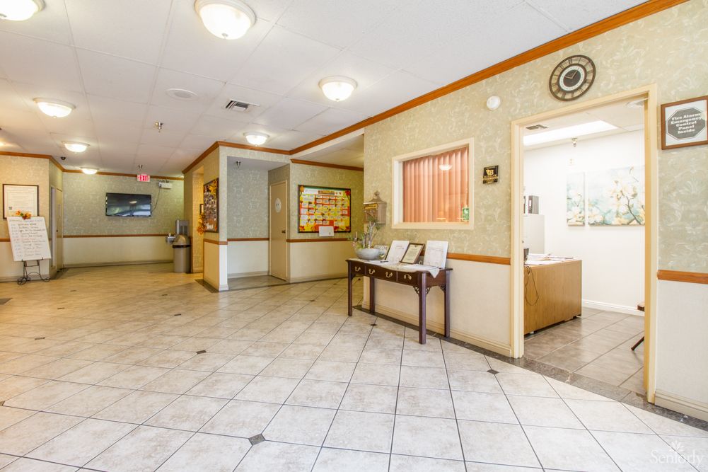 A spacious lobby area with tiled flooring and comfortable seating.