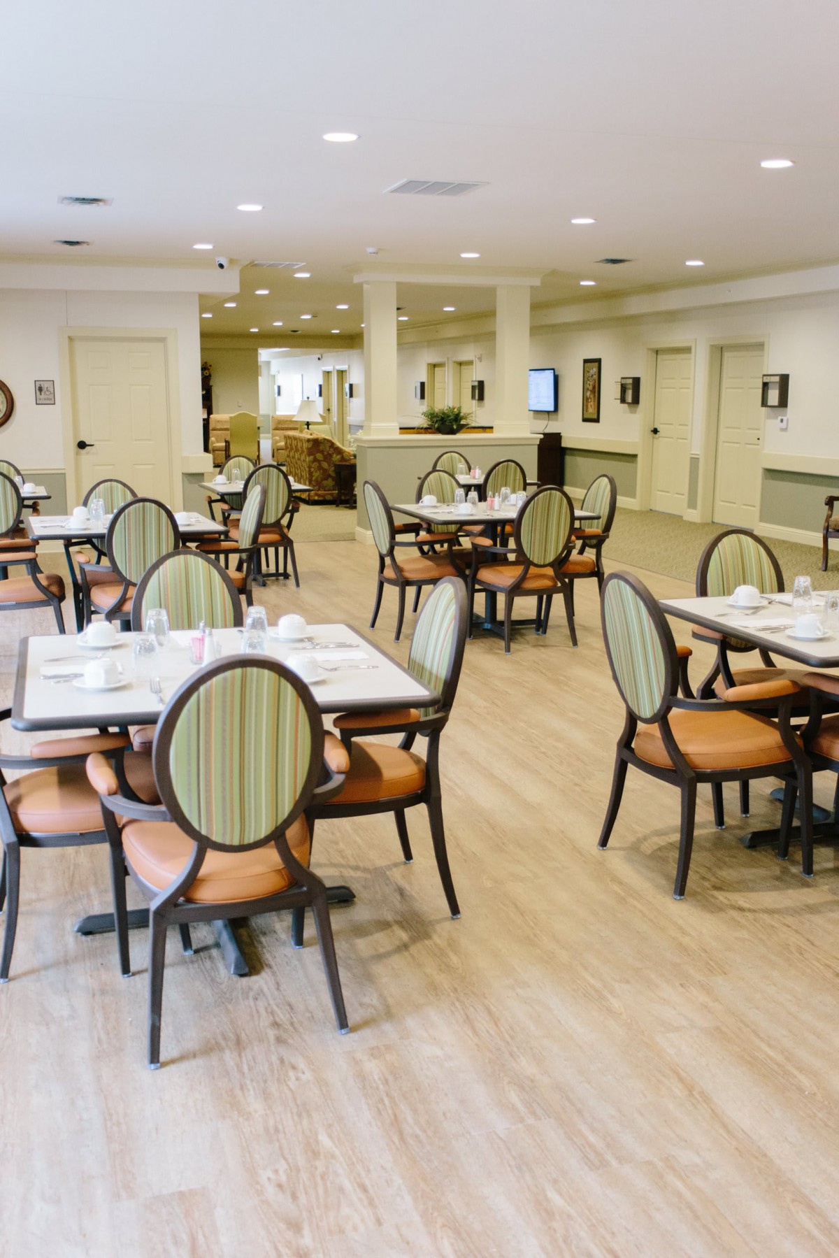 A spacious and well-lit dining area with neatly arranged tables and chairs.