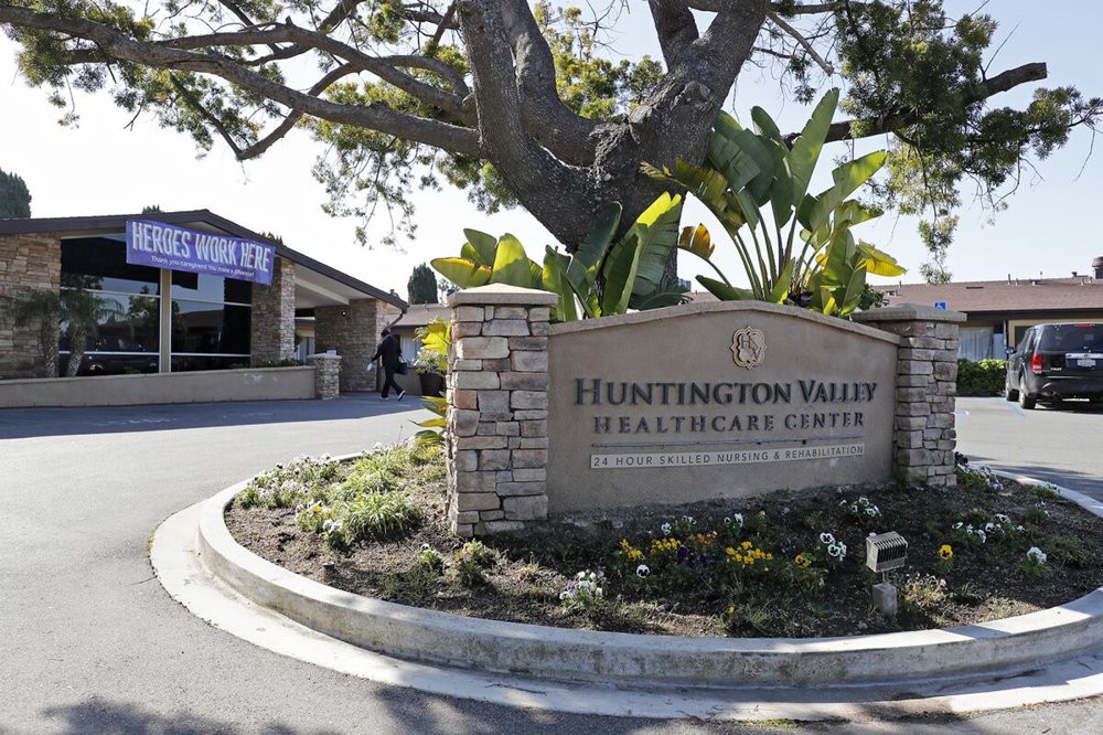 Entrance sign for Huntington Valley Healthcare Center surrounded by landscaping and trees.