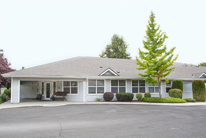 A suburban residential building surrounded by trees.