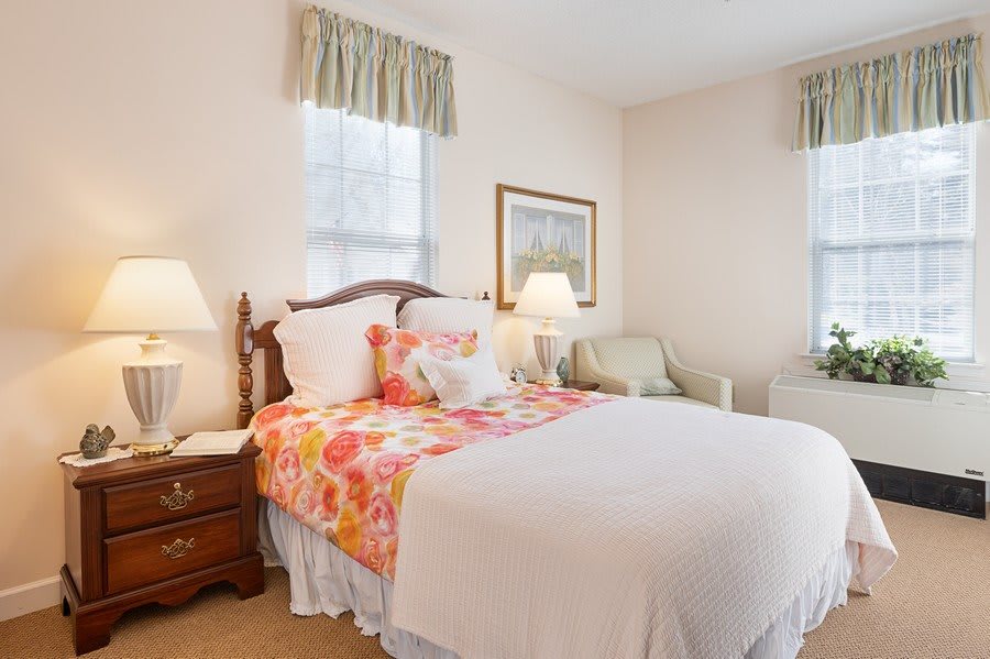 A cozy bedroom with a floral-patterned bedspread and elegant decor.
