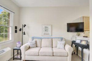 A minimalist living room with a comfortable sofa, wall art, and modern lighting.