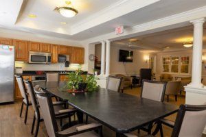 A spacious dining area connected to a kitchen, featuring a large table and comfortable chairs.
