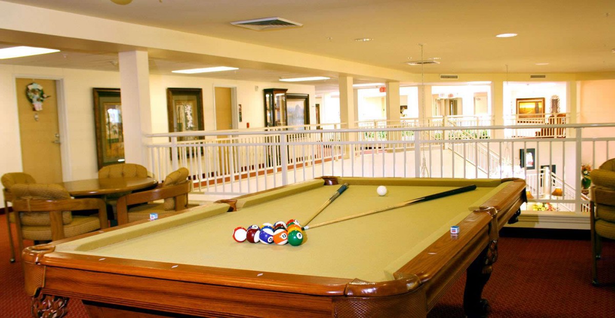 A well-lit recreation room featuring a billiards table.