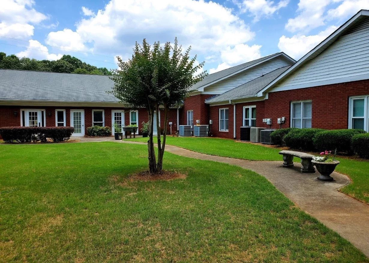 A view of a building complex with green lawns and a central pathway.