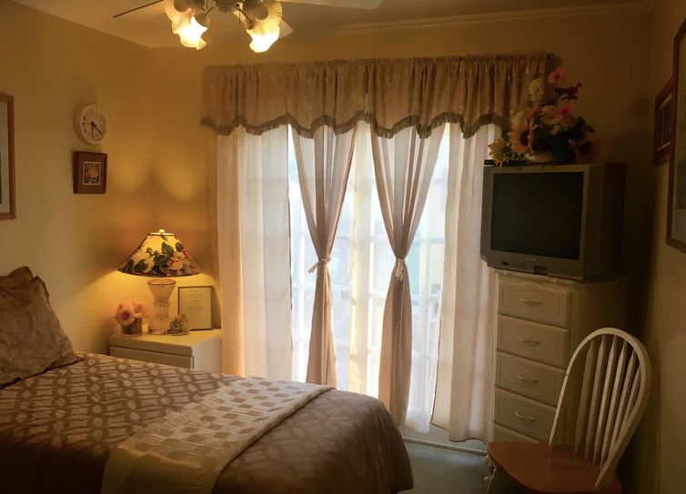 Cozy bedroom interior with elegant curtains and classic furnishings.