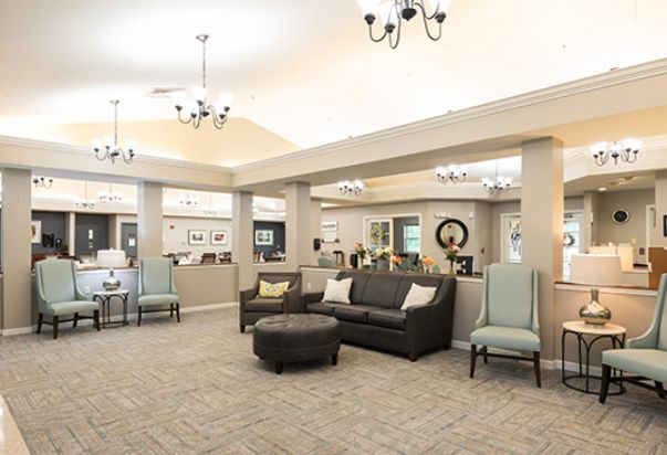 A spacious and well-lit lobby with comfortable seating and elegant chandeliers.