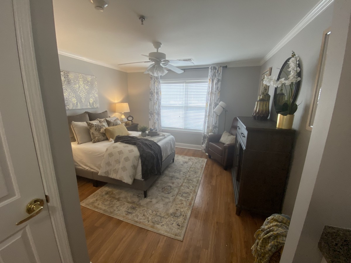 A cozy, well-decorated bedroom with modern furnishings and a large window.