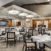 An elegant restaurant dining room with neatly arranged tables and chairs.