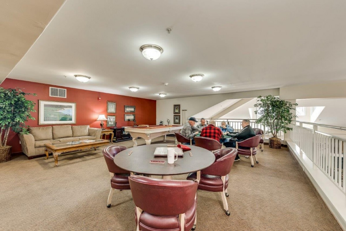 A cozy indoor lounge with seating areas and people socializing.