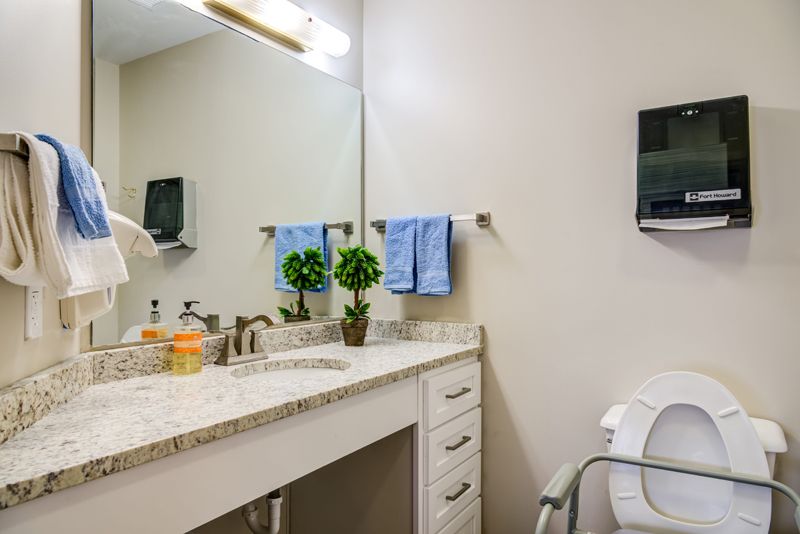 A clean bathroom with a mirror, sink, and neatly arranged towels.