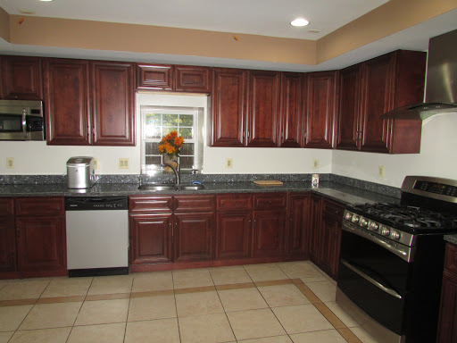 A modern kitchen featuring dark wooden cabinets, sleek countertops, and modern appliances.