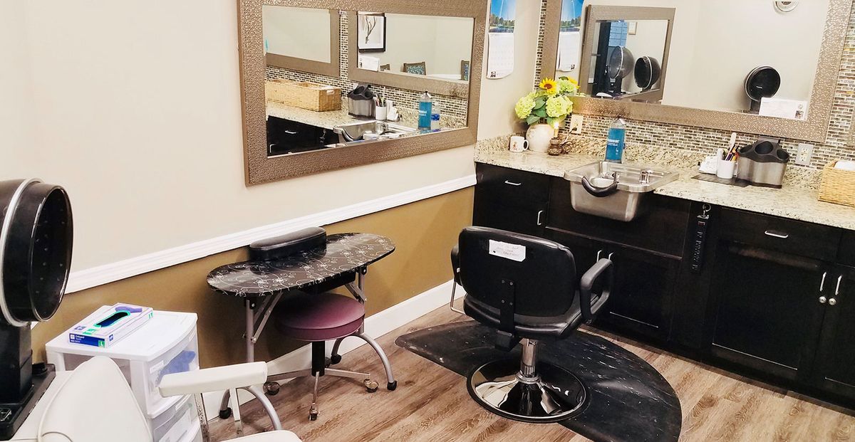 A cozy hair salon setup with a styling chair, mirror, and decorative elements.