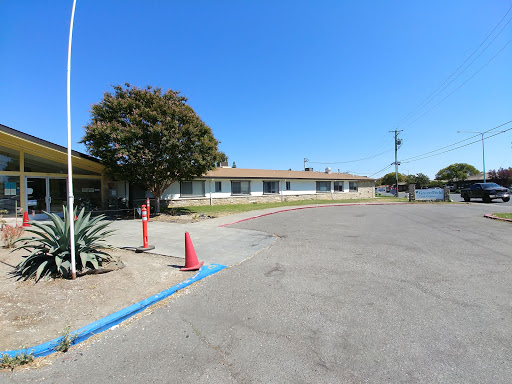 A view of a building from the parking lot under a clear blue sky.