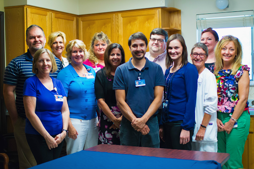 A team of professionals posing together in an office setting.
