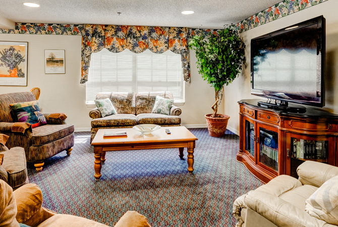 A cozy living room with a sofa, coffee table, and television.
