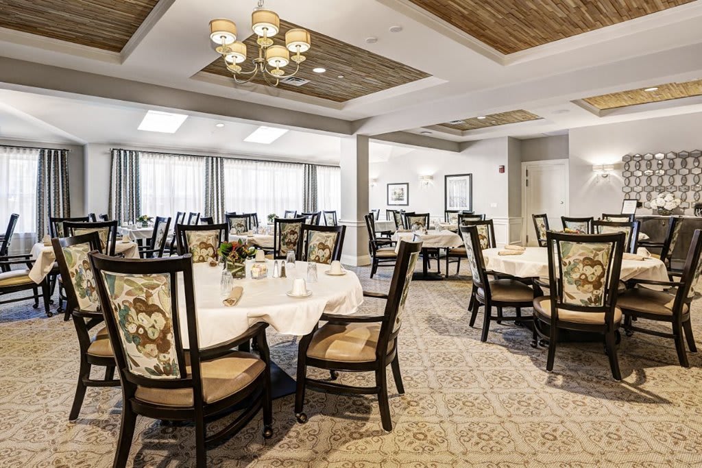 An elegant dining room with neatly arranged tables and chairs, featuring classic interior design elements.