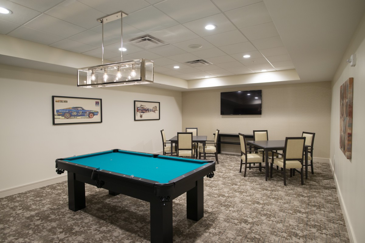 A modern game room featuring a pool table and seating area.