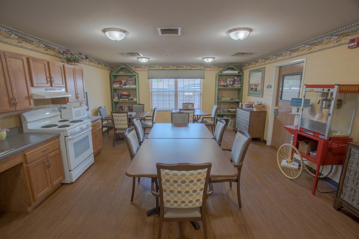 A cozy dining room and kitchen space with a large table surrounded by chairs.