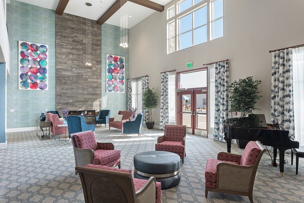 A modern lobby with a comfortable seating area, featuring high ceilings and large windows.