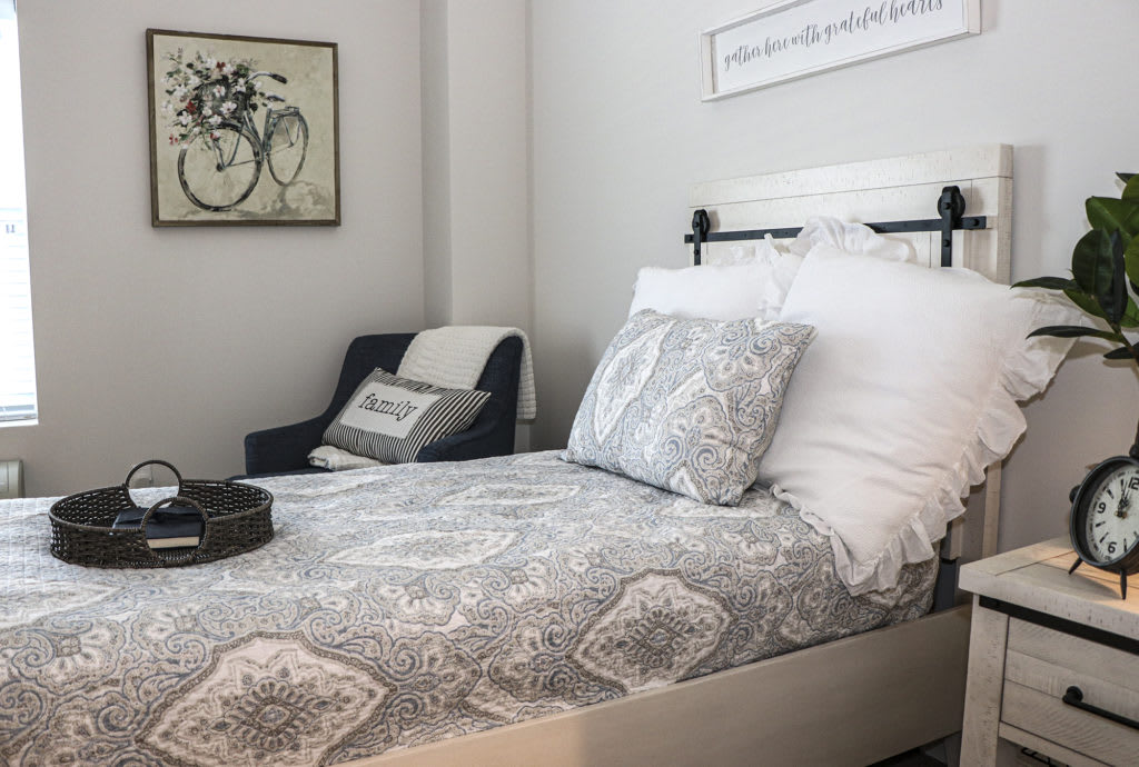A cozy bedroom with a neatly made bed and stylish decor.