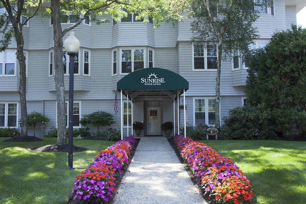A well-landscaped building entrance with a flower-lined walkway.