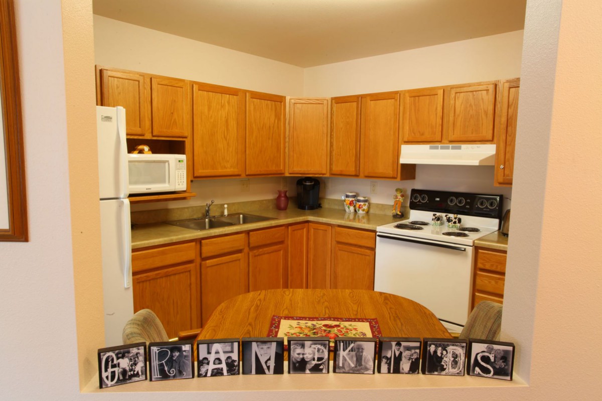 A modern kitchen with wooden cabinets and standard appliances.