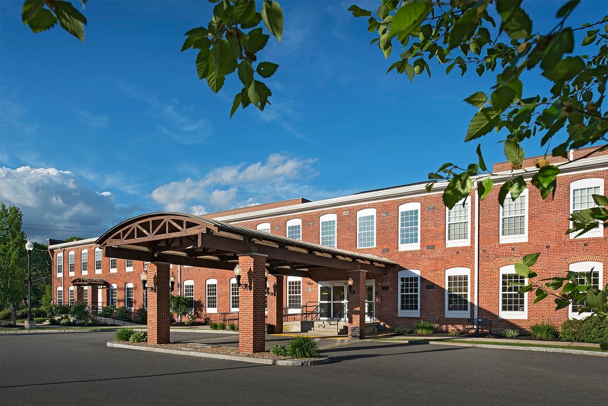 A brick building with an arched entrance under a clear blue sky.