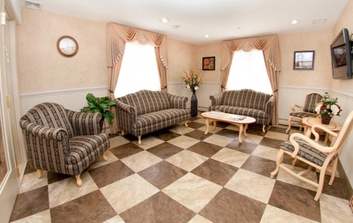 A cozy living room with striped sofas and a checkered floor.