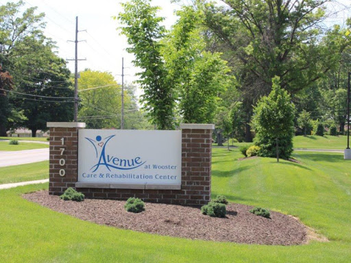 A welcoming sign at the entrance of a facility, surrounded by lush greenery.