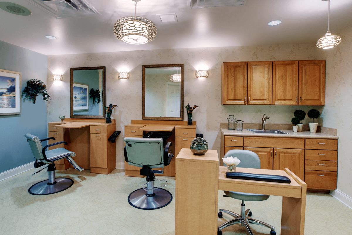 A modern hair salon interior featuring styling chairs, mirrors, and a wash station.
