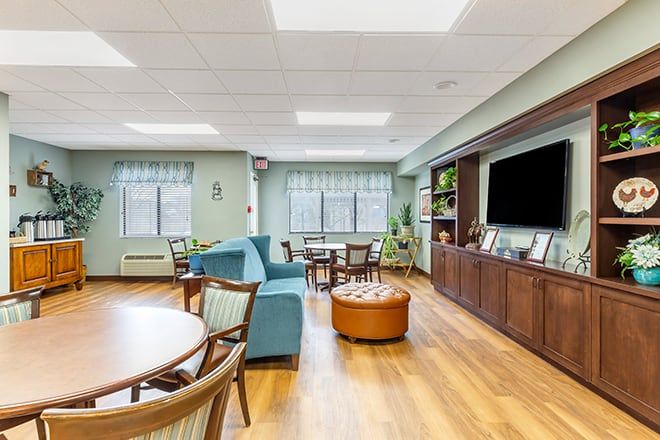 A cozy living room with comfortable seating, a large television, and natural light from the windows.