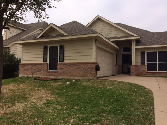 A suburban house with a front lawn and driveway.