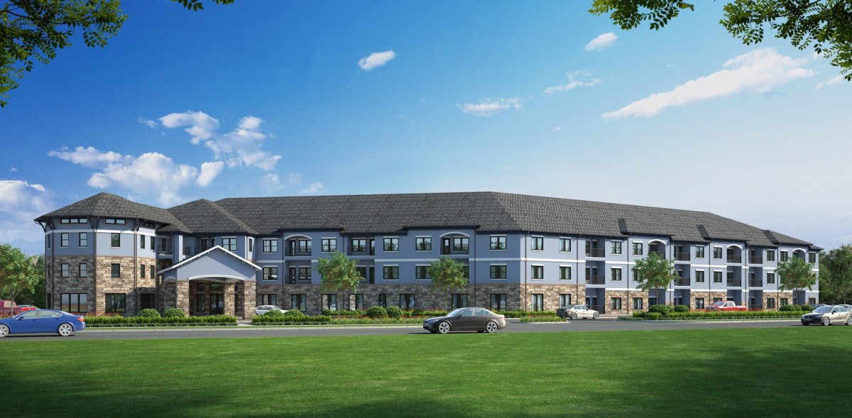 A large residential building with a well-maintained lawn under a clear blue sky.