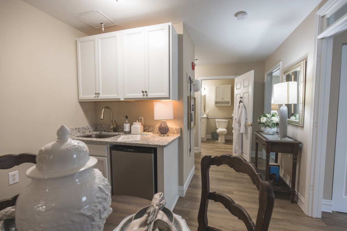 A modern apartment kitchen with white cabinetry and stylish decor.
