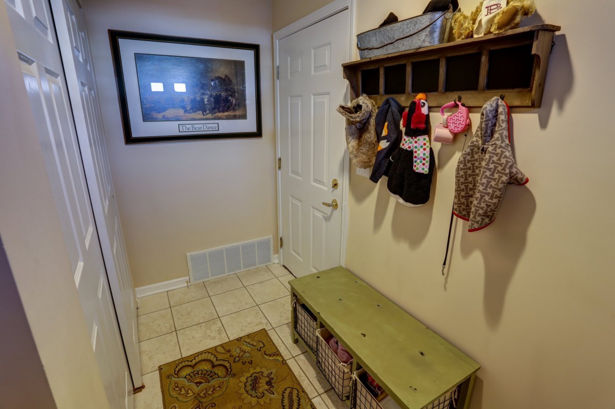 A cozy entryway with a bench, coatrack, and storage baskets.