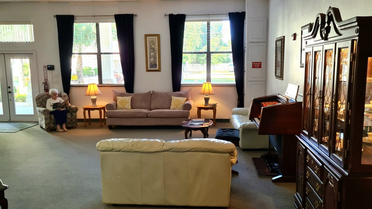 A cozy living room with sofas, lamps, and large windows.