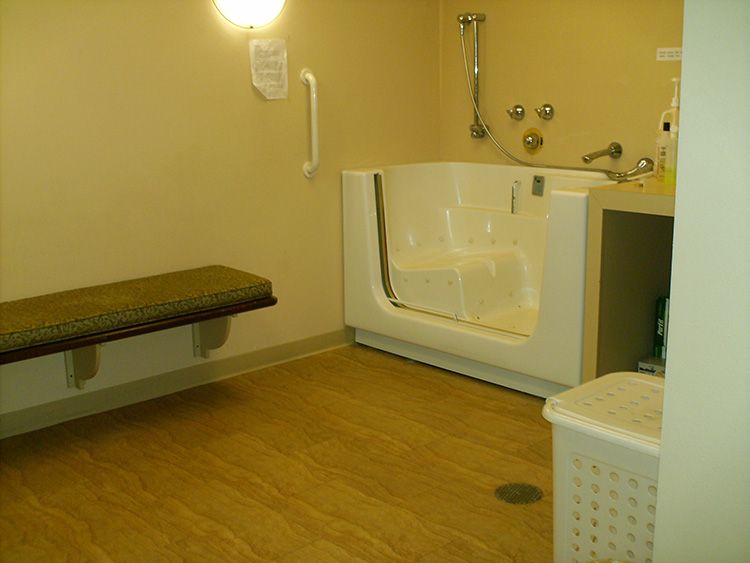 An accessible bathroom with a walk-in bathtub and a bench.