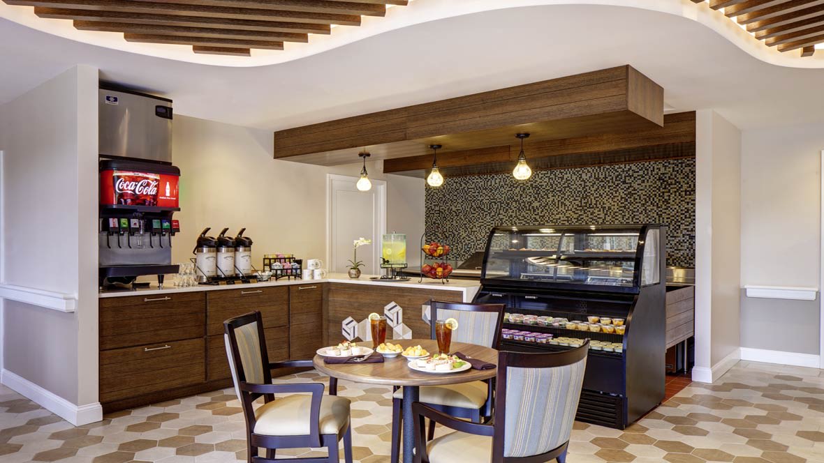 Modern cafe with a pastry display and cozy seating area.