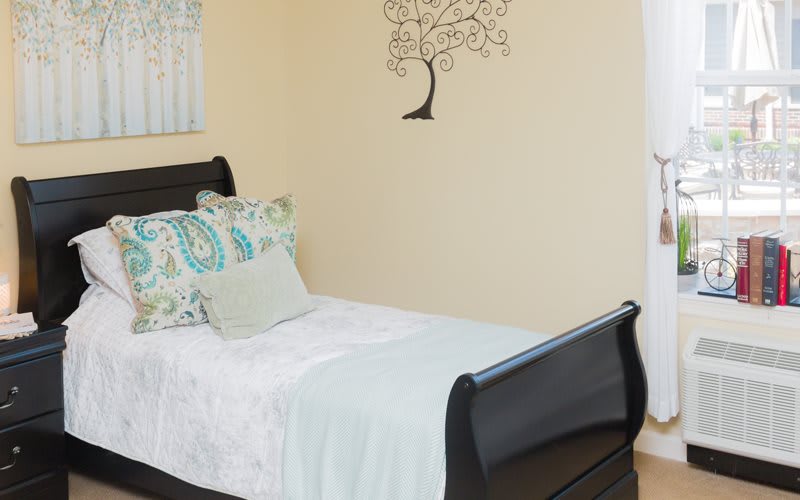A minimalist bedroom with a single bed and wall art.