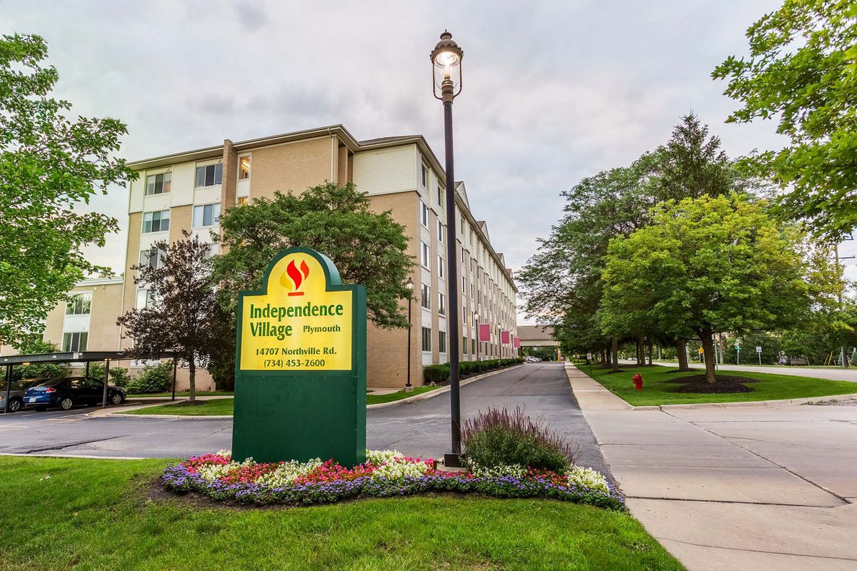Entrance of Independence Village with a well-maintained garden and signage.